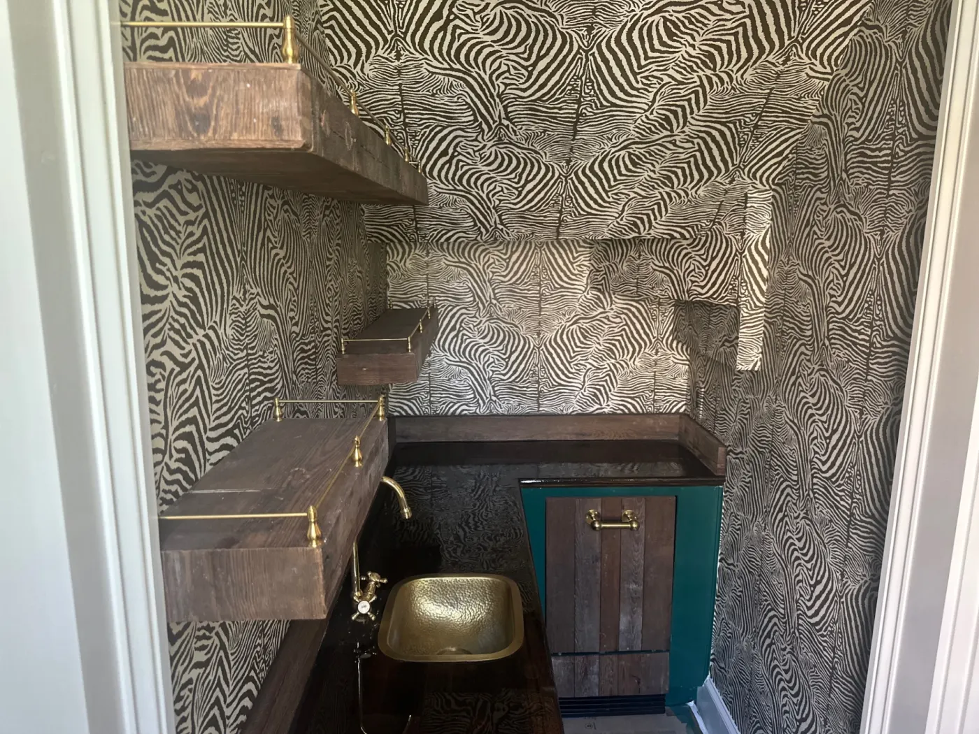 Custom home bar with zebra-pattern wallcovering and dark cabinetry